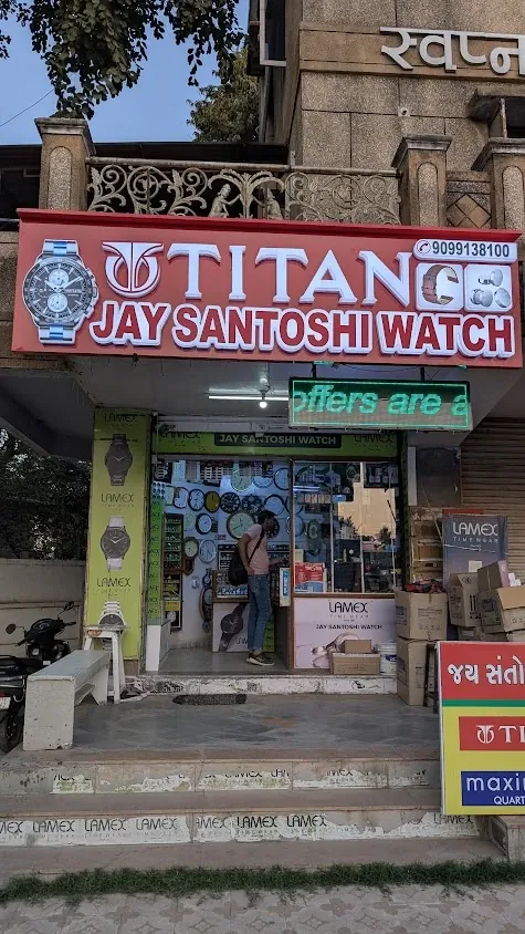 Jay Santoshi Watch shop front with TITAN signboard, Lamex and Maxima boards, Swapna Shilp Complex, Nigam Nagar, Chandkheda